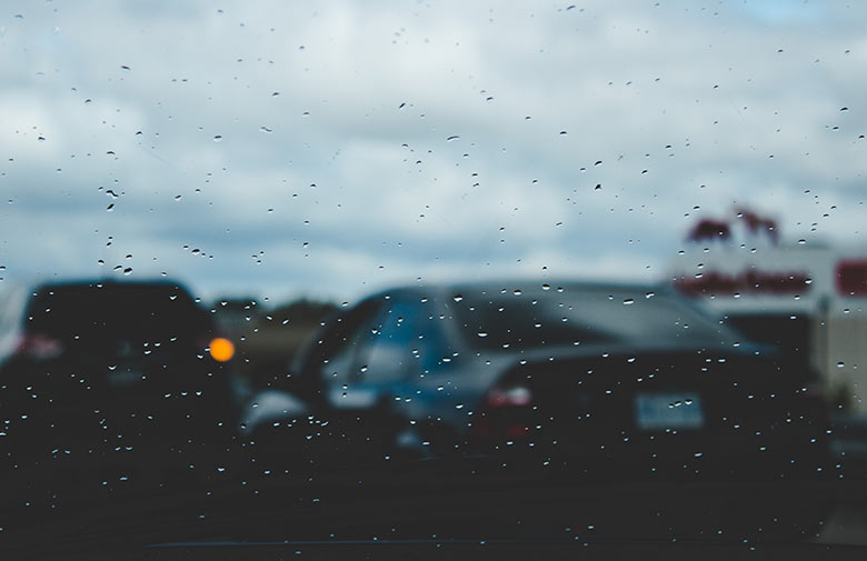 Image of multiple cars taking through a car window while raining