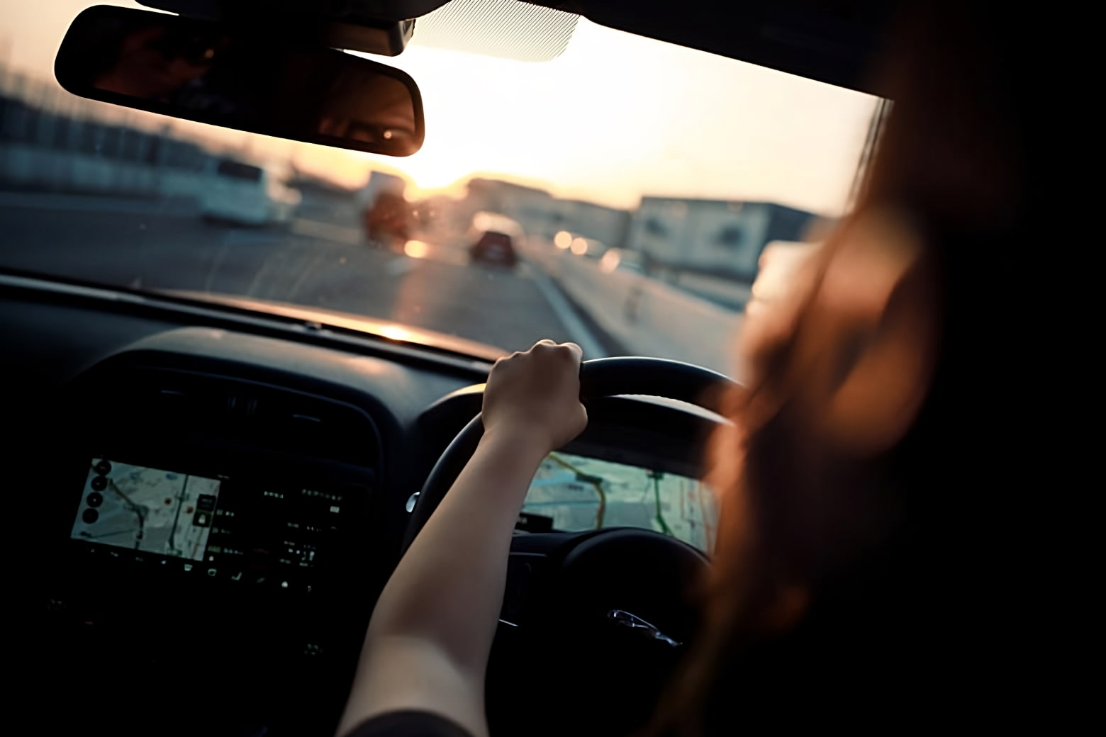 image of image of a person driving the car from back seat point of view